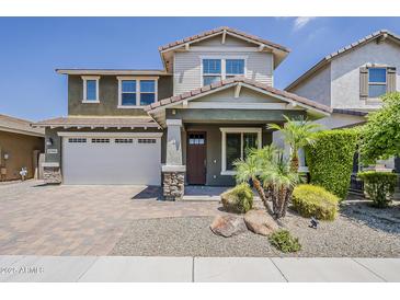 Charming two-story home featuring a brick driveway, a two-car garage, and a landscaped front yard with small palm trees at 3422 E Strawberry Dr, Gilbert, AZ 85298