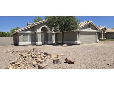 Charming single-story home featuring a well-maintained front yard and an attached two-car garage at 3446 N Ravine --, Mesa, AZ 85215