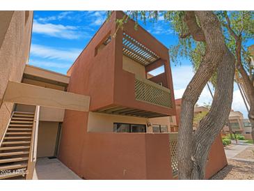Modern, multi-story home featuring a private balcony with unique lattice work and a tree in the foreground at 3500 N Hayden Rd # 2110, Scottsdale, AZ 85251