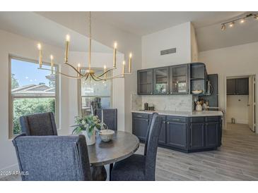 Elegant dining room with a chandelier and views from the windows at 4248 E Jason Dr, Phoenix, AZ 85050