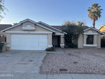 Charming single-story home featuring a two-car garage, gravel landscaping, and a mature palm tree in the front yard at 7760 W Palmaire Ave, Glendale, AZ 85303