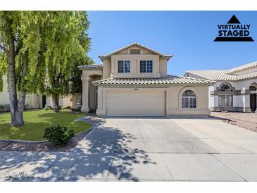 Charming two-story home featuring a neutral color scheme, tile roof, and a well-manicured front lawn at 869 W Shellfish Dr, Gilbert, AZ 85233
