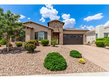 Well-kept single-story home with desert landscaping, stone accents, and a two-car garage door at 9452 W Parkside Ln, Peoria, AZ 85383