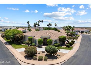 Stunning single-story home with manicured landscaping, mature palm trees, and circular driveway at 11403 E Caron St, Scottsdale, AZ 85259