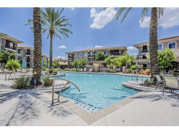 Resort-style pool with lush landscaping, palm trees, and lounge seating in a beautiful apartment complex at 11640 N Tatum Blvd # 2013, Phoenix, AZ 85028