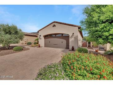 Attached two car garage with brick paved driveway and colorful landscaping adds to the curb appeal of this home at 12738 W Brookhart Way, Peoria, AZ 85383