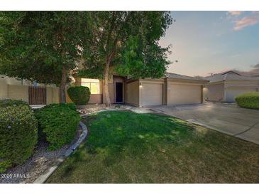 Charming home featuring a well-maintained lawn, mature trees, and a convenient two-car garage at 13633 W Alvarado Dr, Goodyear, AZ 85395