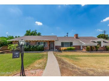 Charming single-story brick home with a well-manicured lawn and a welcoming pathway leading to the front door at 1407 E 1St St, Mesa, AZ 85203