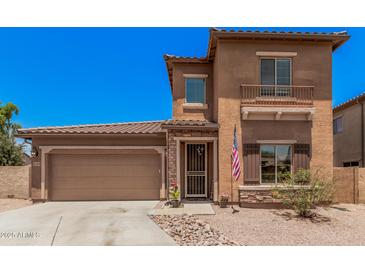 Two-story home with a two car garage, a desert rock yard and a quaint, covered entry way at 16284 W Desert Mirage Dr, Surprise, AZ 85379