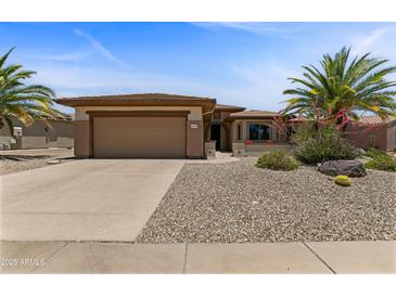Charming single-story home featuring a desert landscape, two-car garage and a neutral color palette at 16716 W Rincon Peak Dr, Surprise, AZ 85387