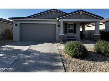Charming single-story home with well-maintained landscaping, a spacious driveway, and a welcoming covered porch at 18230 W Poston Dr, Surprise, AZ 85387