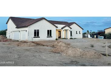 Charming single-story home featuring a stucco exterior, tiled roof, and decorative wrought iron door at 22504 W Meade Ln, Buckeye, AZ 85326