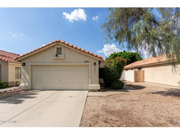 Charming single-story home featuring a red tile roof, two-car garage, and low-maintenance front yard at 7826 W Mcrae Way, Glendale, AZ 85308