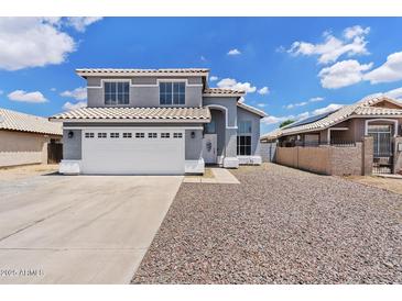 Charming two-story home featuring a well-maintained front yard with a spacious driveway and attached two-car garage at 8750 W Granada Rd, Phoenix, AZ 85037
