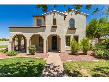 Charming two-story home featuring a stucco facade, arched entryways, and a well-manicured front yard with lush landscaping at 20409 W Thayer St, Buckeye, AZ 85396