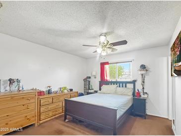 Spacious bedroom featuring a ceiling fan, natural light and neutral walls at 4122 W Las Palmaritas Dr, Phoenix, AZ 85051