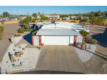 Charming home featuring a white facade, two-car garage, and desert landscaping at 420 S 80Th Pl, Mesa, AZ 85208