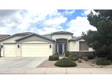 Charming single-story home with a three-car garage and well-manicured front yard landscaping at 8256 W Bloomfield Rd, Peoria, AZ 85381