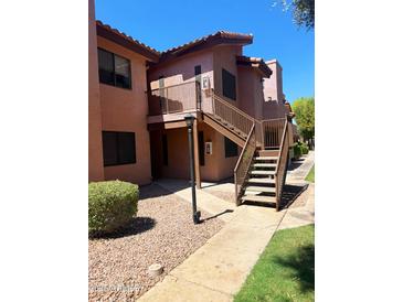 View of a multi-story apartment building with exterior stairs, a landscaped path, and neutral paint at 1075 E Chandler Blvd # 220, Chandler, AZ 85225