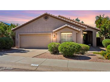 Charming single-story home featuring a two-car garage, desert landscaping, and a neutral color palette at 11861 E Becker Ln, Scottsdale, AZ 85259