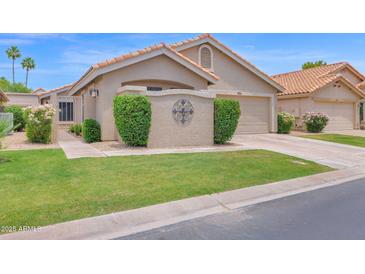 Charming home featuring a well-manicured lawn, desert landscaping, and a warm, inviting facade at 19107 N 94Th Ave, Peoria, AZ 85382