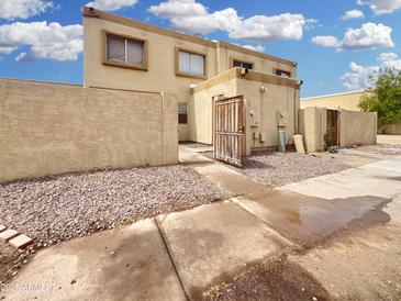 Tan two-story townhome featuring a private gated courtyard and desert landscaping for low maintenance at 4416 E Riverside St, Phoenix, AZ 85040