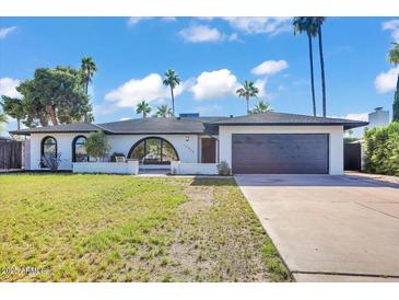 Attractive single-story home featuring a well-maintained lawn, modern design, a garage door, and desert landscaping at 10844 N 37Th Way, Phoenix, AZ 85028
