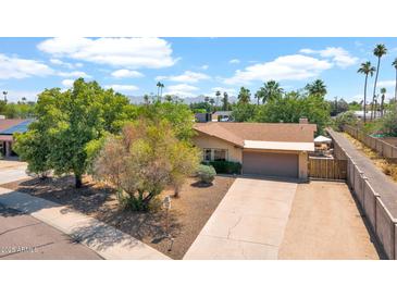 Charming single-story home with a well-manicured lawn and mature trees, creating a welcoming curb appeal at 11011 N 39Th St, Phoenix, AZ 85028