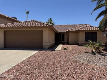Charming single-story home featuring a tile roof, two car garage, and low maintenance rock landscaping at 4301 E Amberwood Dr, Phoenix, AZ 85048