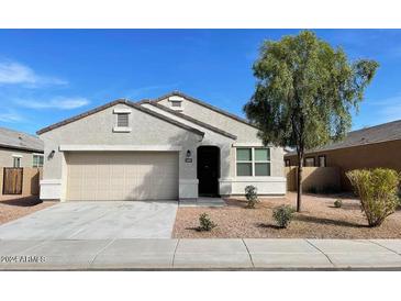 Charming single-story home featuring a low maintenance landscape, two-car garage, and neutral color palette at 6999 S Blue Hills Dr, Buckeye, AZ 85326