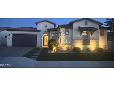 Inviting single-story home with lush lawn, stone accents, an arched entry, and a two car garage at 2121 E Aquarius Pl, Chandler, AZ 85249