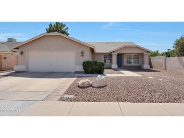 Charming single-story home showcasing a low maintenance desert-style front yard and a two-car garage at 23638 N 41St Ave, Glendale, AZ 85310