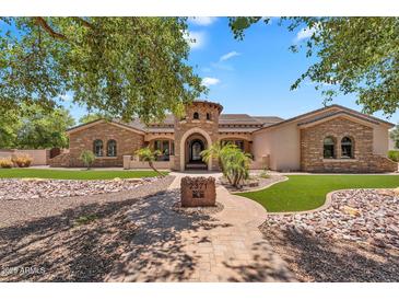 Stunning stone home featuring a well-manicured front yard and desert landscaping at 2371 E Sanoque Ct, Gilbert, AZ 85298