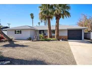 Charming single-story home with desert landscaping and mature palm trees at 4714 N Miller Rd, Scottsdale, AZ 85251