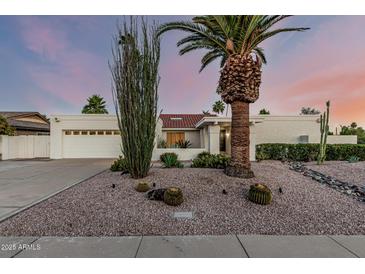 Charming single-story home featuring desert landscaping, gravel, and a well-maintained yard at sunset at 6119 E Sandra Ter, Scottsdale, AZ 85254