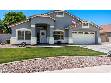 Charming single-story home with well-manicured lawn and a two-car garage at 2111 E Rawhide St, Gilbert, AZ 85296