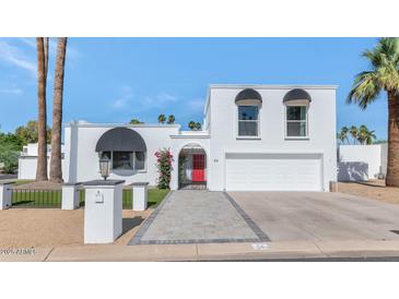 Charming white two-story home with a red front door, desert landscaping, and a two-car garage at 34 E Boca Raton Rd, Phoenix, AZ 85022