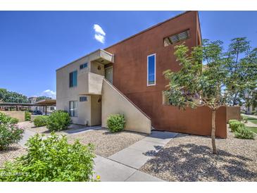 Attractive two-story condo with a stucco exterior, low maintenance landscaping, and a bright blue sky at 3600 N Hayden Rd # 2310, Scottsdale, AZ 85251