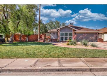 Charming single-story home featuring a well-manicured lawn and mature trees at 5144 W Sweetwater Ave, Glendale, AZ 85304