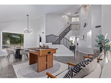 Spacious living room featuring a foosball table, dining area, and staircase at 6449 E Paradise Ln, Scottsdale, AZ 85254