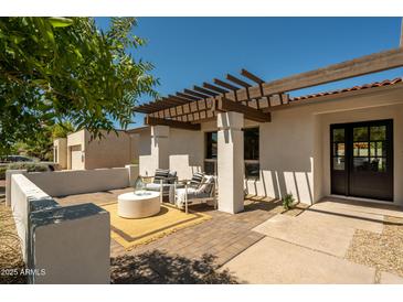 Charming outdoor patio with pergola, brick pavers, and comfortable seating for enjoying the backyard views at 7618 N Via Del Paraiso --, Scottsdale, AZ 85258