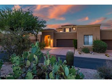 Inviting desert home featuring a charming entrance, two-car garage, and beautiful desert landscaping at 9270 E Thompson Peak Pkwy # 347, Scottsdale, AZ 85255