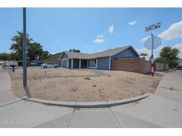Charming single-Gathering home with blue exterior, well-maintained landscaping, and attached two-car garage at 14412 N 39Th Ave, Phoenix, AZ 85053