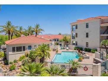 Resort-style community pool featuring lush landscaping and lounge area, perfect for relaxation at 16715 E El Lago Blvd # 212, Fountain Hills, AZ 85268