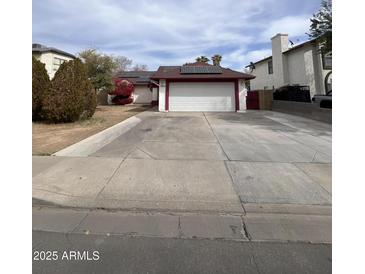 Charming single-story home with a spacious driveway and solar panels on the roof at 2533 N 88Th Ln, Phoenix, AZ 85037