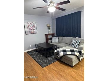 Comfortable living room with gray sofa, coffee table, and ceiling fan at 520 N Stapley Dr # 265, Mesa, AZ 85203