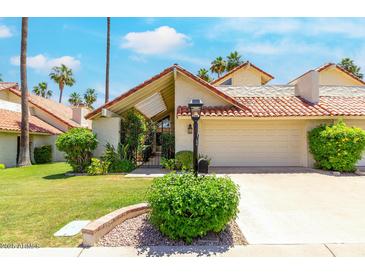 Charming home featuring a well-maintained lawn, mature landscaping, and a two-car garage at 7115 E Buena Terra Way, Paradise Valley, AZ 85253