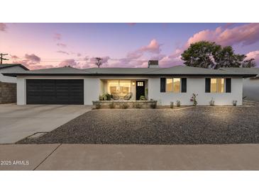 Charming single-story home with a dark-colored garage door and well-maintained landscaping in the front yard at 8341 E Hubbell St, Scottsdale, AZ 85257