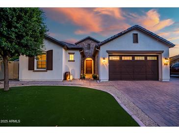 Inviting home exterior with a well-manicured lawn, beautiful stonework, and a welcoming entrance at 15803 W Almeria Rd, Goodyear, AZ 85395