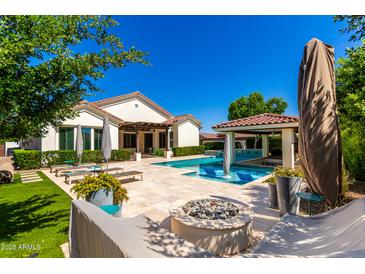 Outdoor oasis with a sparkling pool, lounge chairs, fire pit, and covered patio perfect for entertaining at 4332 S Oregon Ct, Chandler, AZ 85248